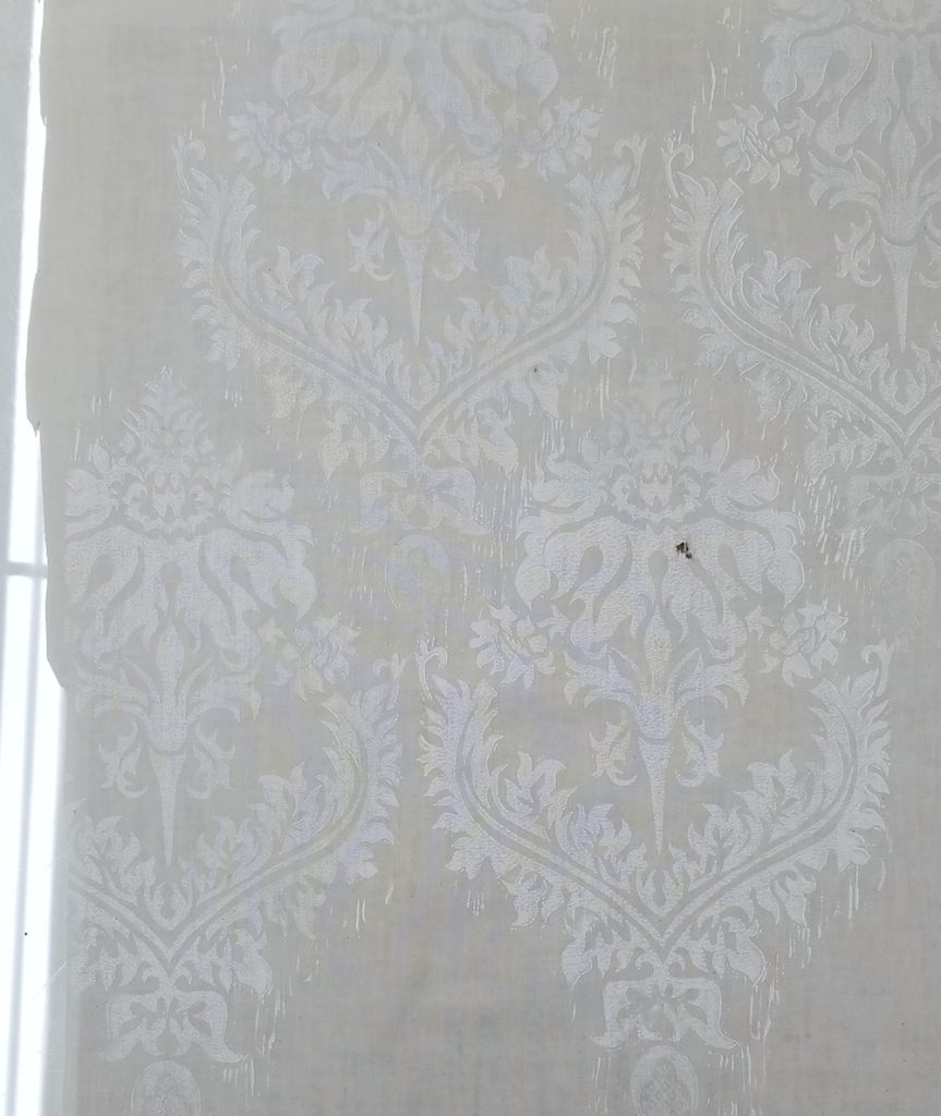 a brocade pattern printed in white ink on off-white fabric