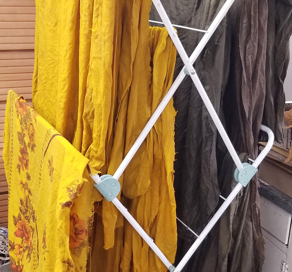 gold and brown fabrics hanging in a drying rack